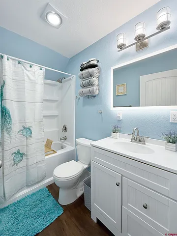 a bathroom with a granite countertop toilet sink and mirror