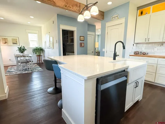 a kitchen with sink and view of living room