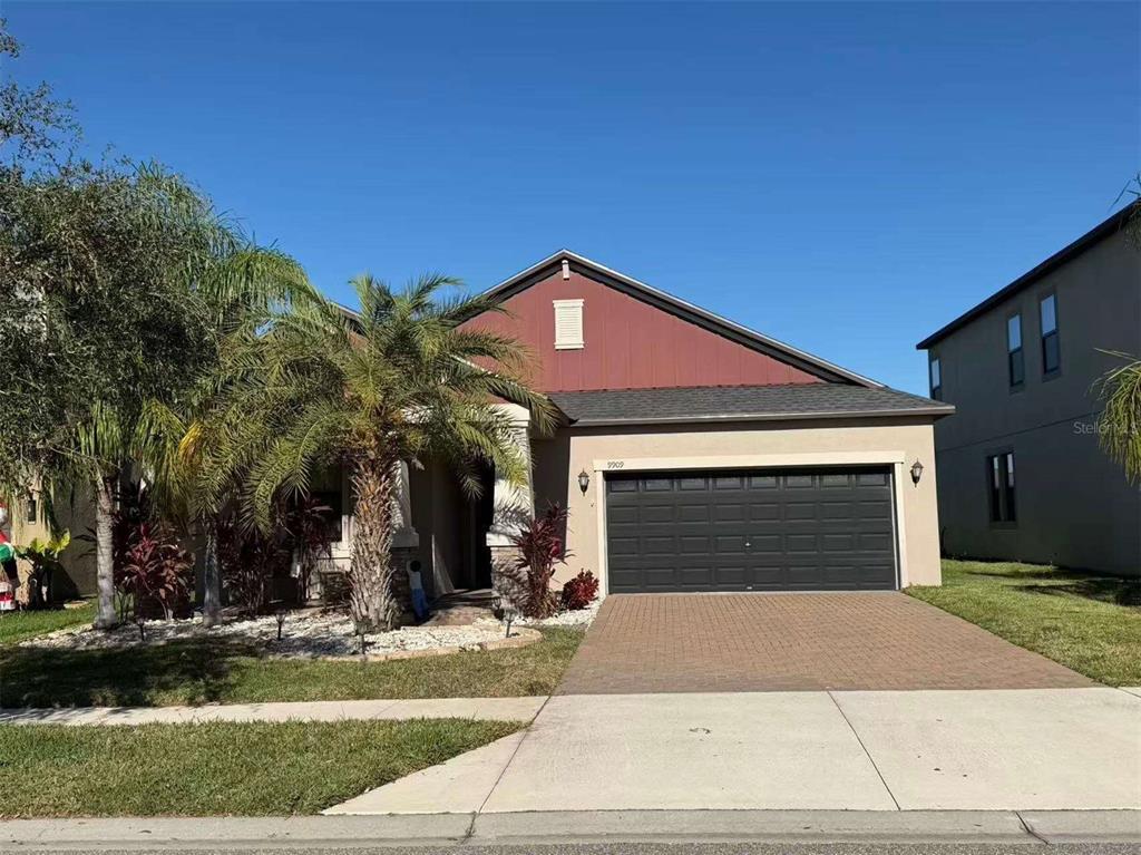 9909 Victory Gallop Loop Ruskin, FL 33573 - Photo 14 of 18 a front view of a house with a yard