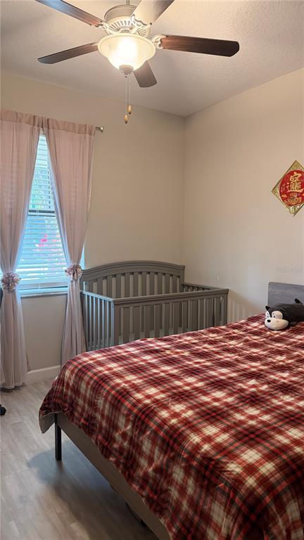 9909 Victory Gallop Loop Ruskin, FL 33573 - Photo 15 of 18 a bed sitting in a bedroom next to a small yard