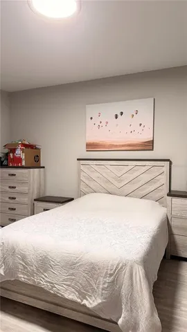 a bedroom with a bed and painting on the wall