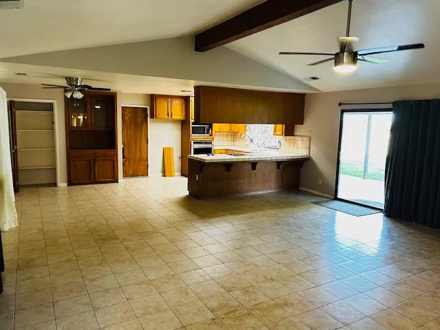 a view of a kitchen with kitchen island stainless steel appliances granite countertop a sink and a refrigerator