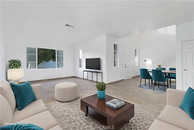 a living room with furniture a flat screen tv and a large window