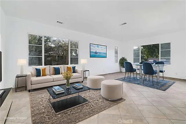 a living room with furniture a large window and a table