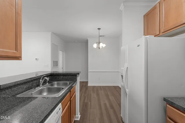 an empty room with wooden floor ceiling fan and windows