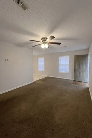 a view of a livingroom with a ceiling fan and window