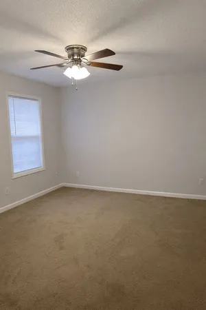 a view of a room with window and ceiling fan