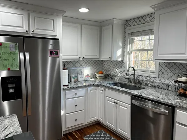 a kitchen with stainless steel appliances granite countertop a refrigerator sink and cabinets