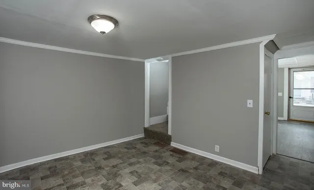 a view of a kitchen with refrigerator and white cabinets