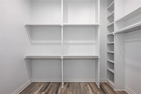 a view of walk in closet with empty racks