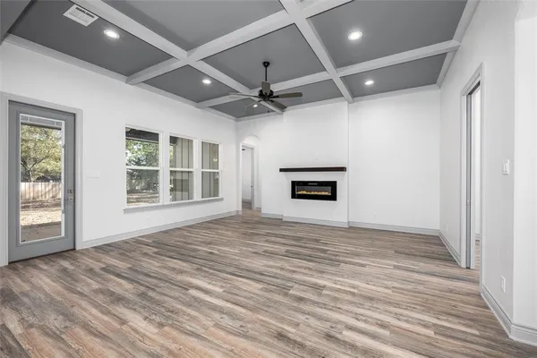 an empty room with windows and fireplace