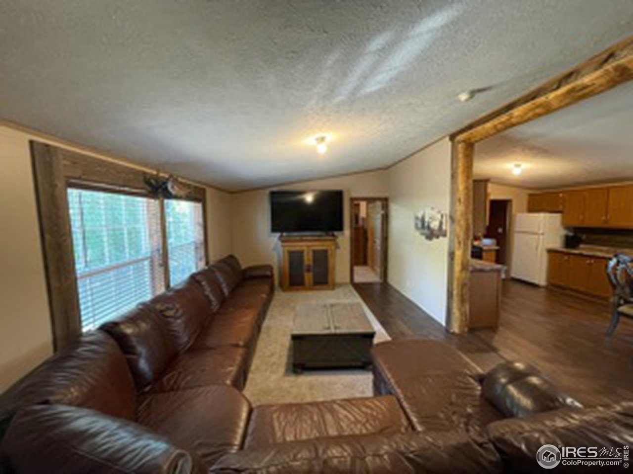 a large white living room with a couch and wooden floor