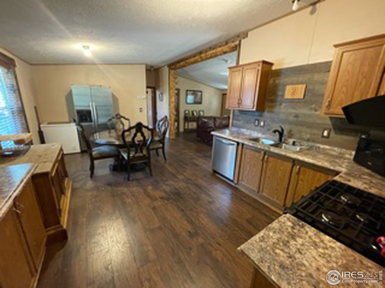 2500 East Harmony Road, Unit 62 Fort Collins, CO 80528 - Photo 4 of 13 a open kitchen with stainless steel appliances granite countertop a stove top oven a sink dishwasher and cabinets with wooden floor