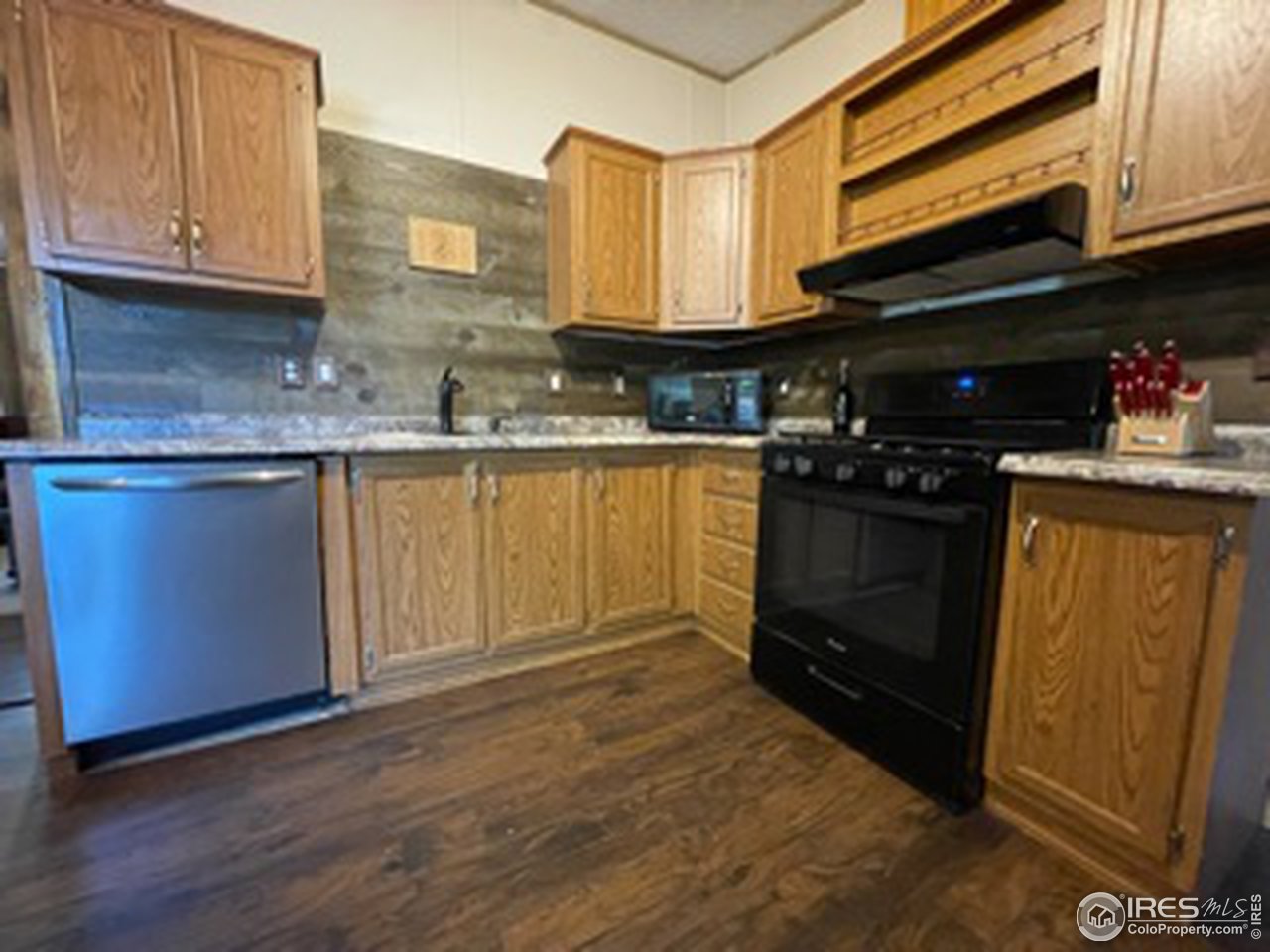 2500 East Harmony Road, Unit 62 Fort Collins, CO 80528 - Photo 5 of 13 a kitchen with stainless steel appliances granite countertop a stove a sink and a microwave