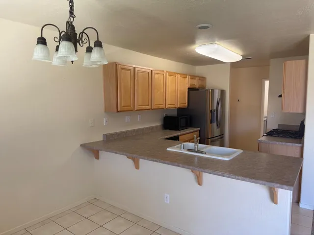 a kitchen with a sink a refrigerator and a granite counter top