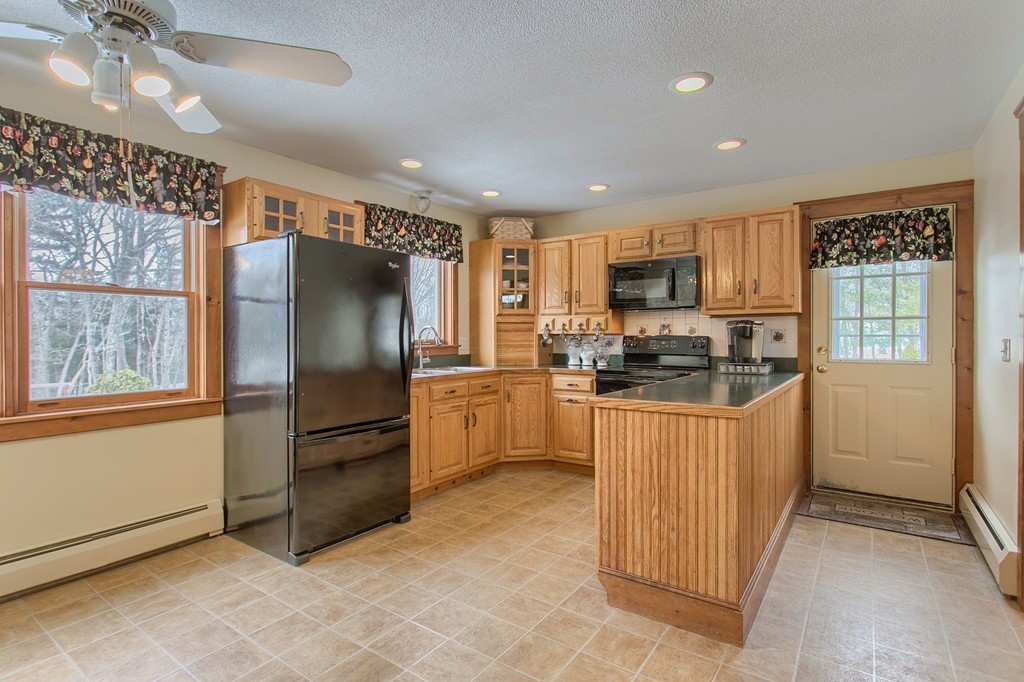 253 New Boston Road Sturbridge, MA 01566 - Photo 4 of 30 a kitchen with granite countertop a refrigerator and a stove top oven