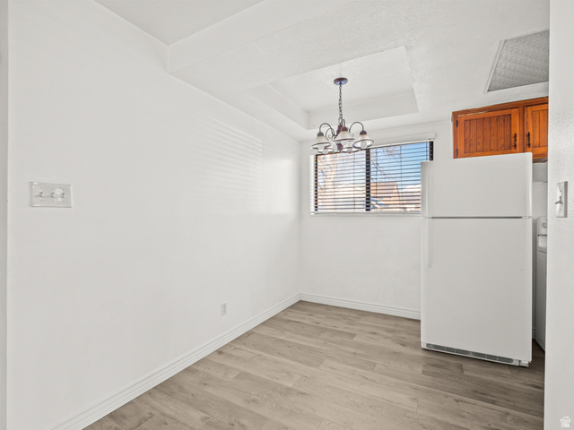 460 200 South Provo, UT 84606 - Photo 18 of 66 Unfurnished dining area featuring light wood-type flooring, a chandelier, and a raised ceiling