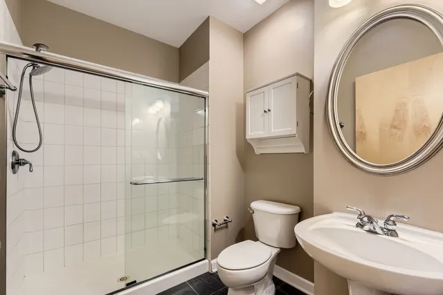 a bathroom with a toilet a sink and mirror