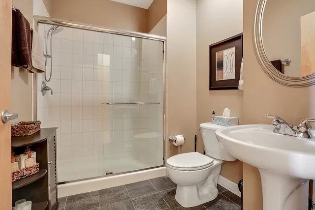 a bathroom with a sink a toilet and shower