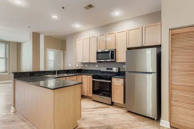 a kitchen with granite countertop a sink stove and refrigerator