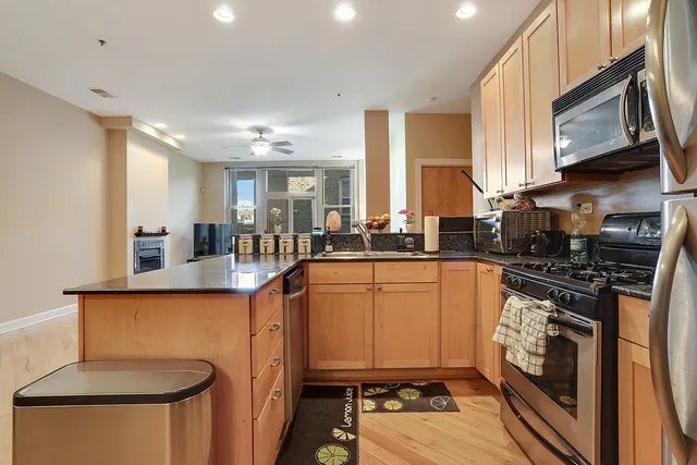a kitchen with stainless steel appliances granite countertop a stove a sink and a microwave