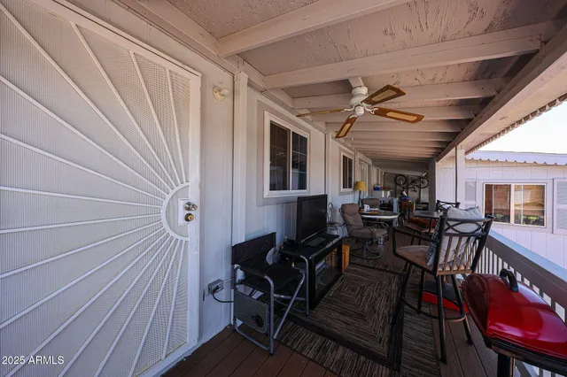 a view of a patio with table and chairs with wooden floor and fence