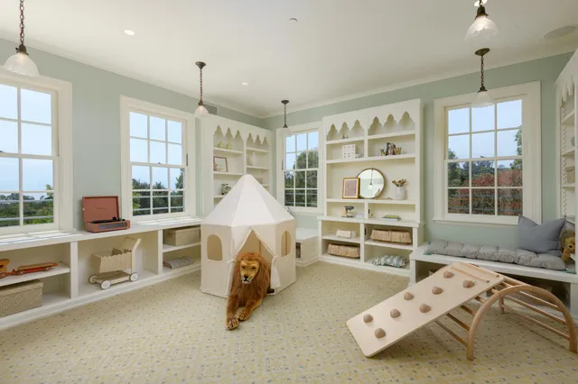 a view of an empty room with furniture and windows
