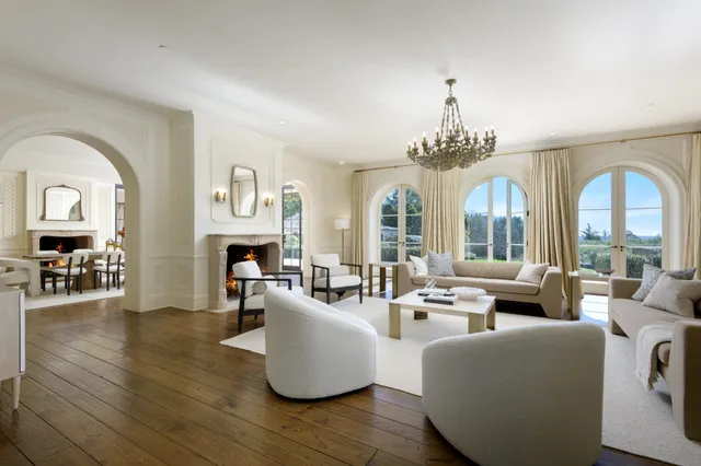 a living room with fireplace furniture and a large window
