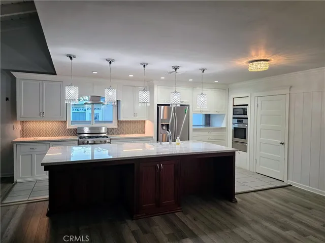a kitchen with kitchen island stainless steel appliances a sink and cabinets