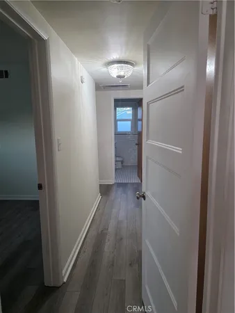a view of a hallway with wooden floor