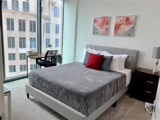 a bed sitting in a bedroom next to a large window