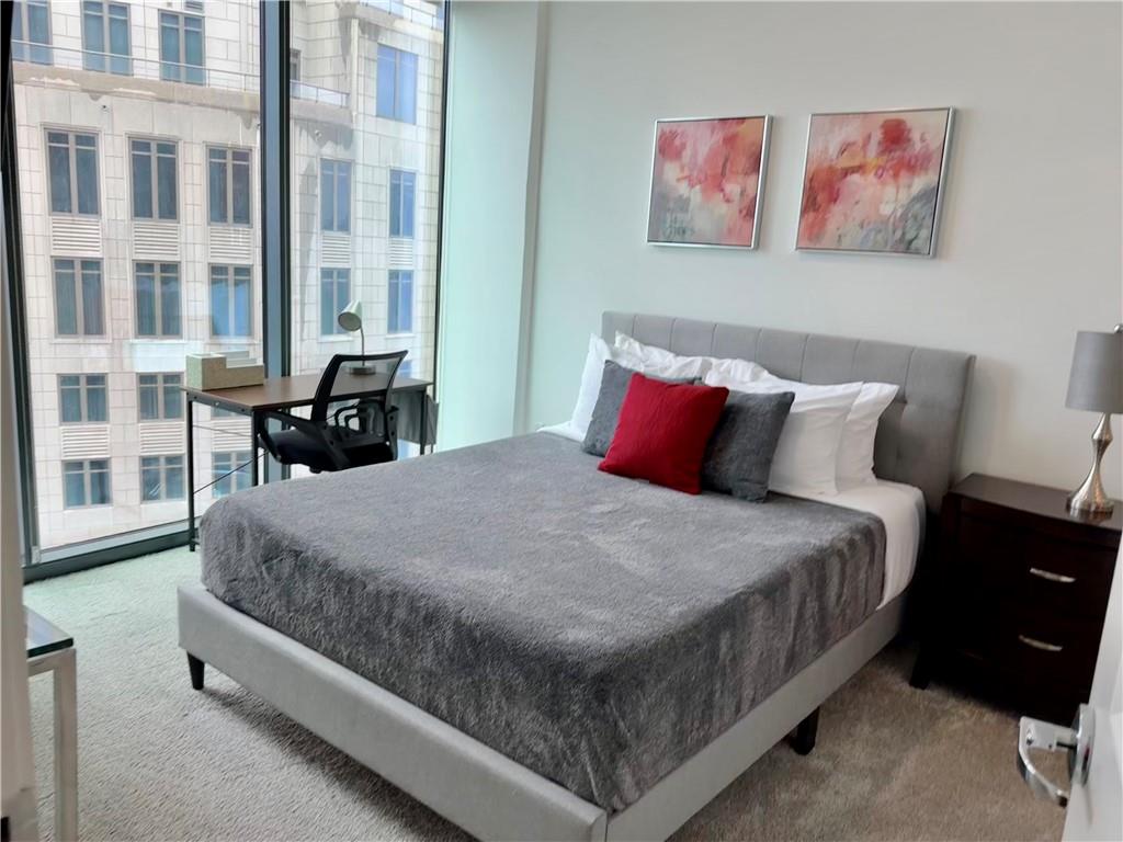 3382 Peachtree Road Northeast, Unit S12 Atlanta, GA 30326 - Photo 11 of 29 a bed sitting in a bedroom next to a large window