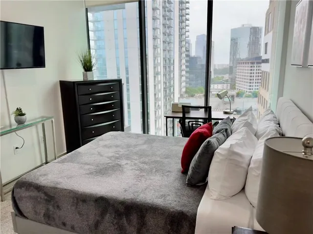 a bedroom with a bed and dresser with mirror