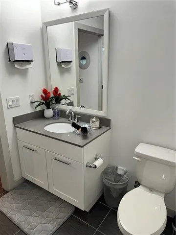 a bathroom with a toilet sink and mirror