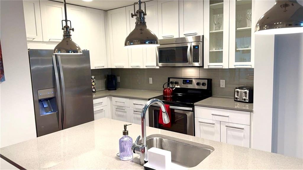 3382 Peachtree Road Northeast, Unit S12 Atlanta, GA 30326 - Photo 15 of 29 a kitchen with stainless steel appliances granite countertop a sink a stove and a refrigerator