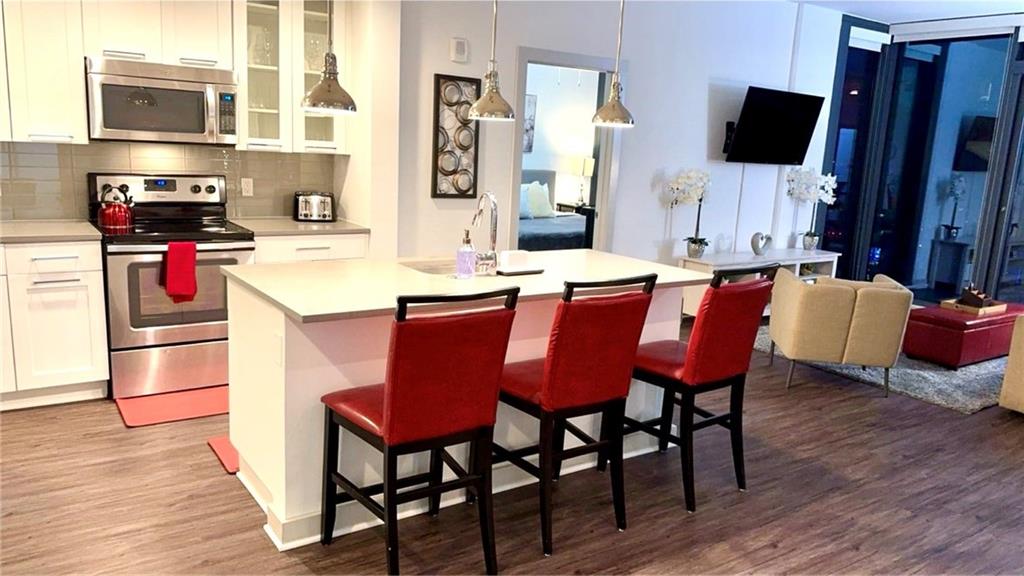3382 Peachtree Road Northeast, Unit S12 Atlanta, GA 30326 - Photo 17 of 29 a dining room with a wooden floor a chandelier a wooden table and chairs