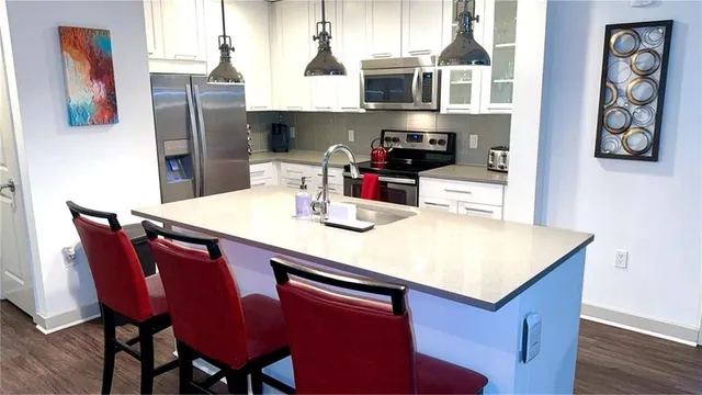 a kitchen with stainless steel appliances wooden cabinets dining table and chairs