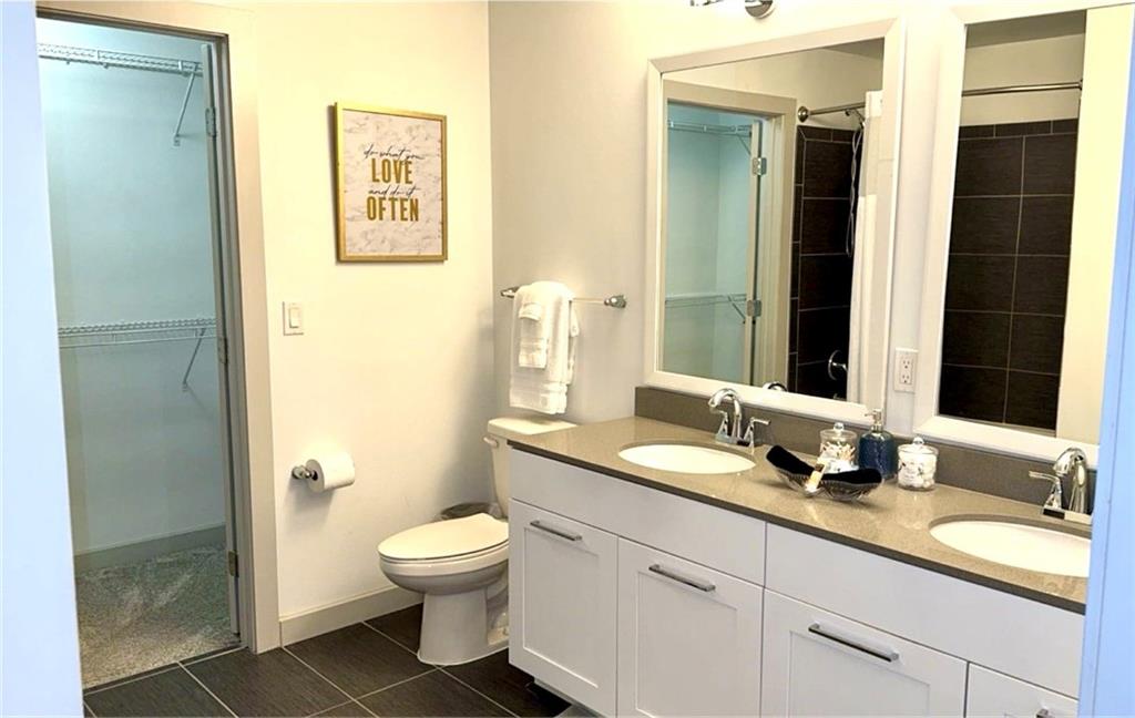 3382 Peachtree Road Northeast, Unit S12 Atlanta, GA 30326 - Photo 26 of 29 a bathroom with a granite countertop sink toilet a large mirror a shower and a mirror