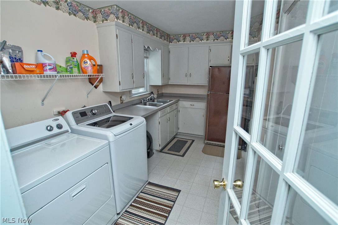 1273 Ford Road Lyndhurst, OH 44124 - Photo 23 of 32 French door leads to the first floor laundry room with washer and dryer. Stainless steel sink with plenty of cabinet space and closet behind door. Around the corner is the half bath and entrance to the lower level.
