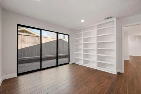 a view of a room with wooden floor and doors