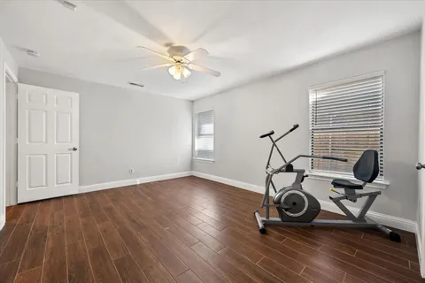 a view of a workspace with wooden floor and gym equipment
