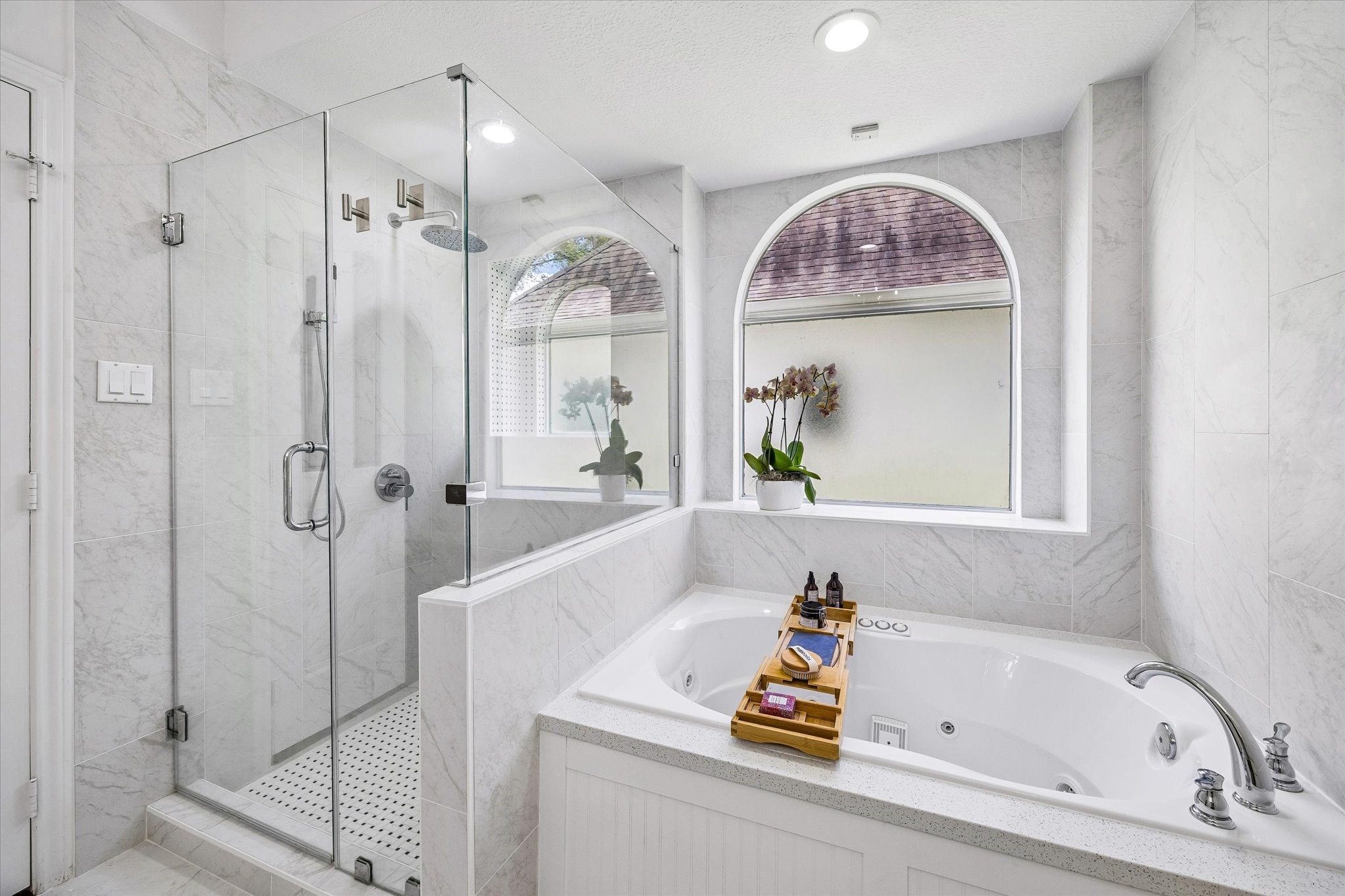 146 Golden Shadow Circle Spring, TX 77381 - Photo 21 of 41 The primary bath offers a true spa-like experience, featuring glass walk-in shower, a relaxing jetted soaking tub, and elegant marble-inspired finishes. Arched windows fill the space with natural light, creating a bright and tranquil retreat.