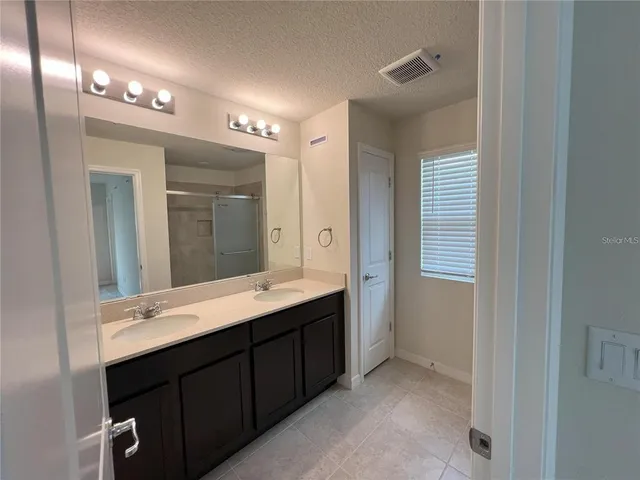 a bathroom with a double vanity sink and a mirror