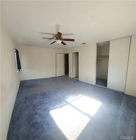 an empty room with windows and closet