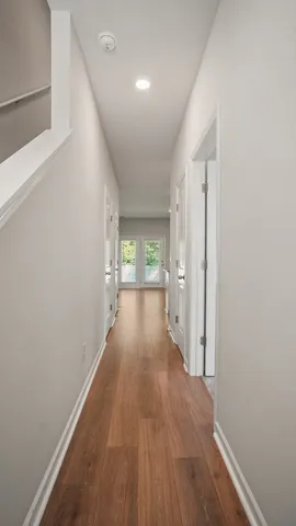 a view of a hallway with wooden floor