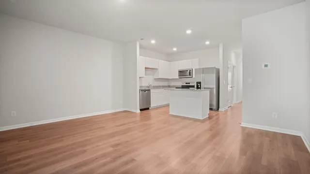 a view of kitchen with granite countertop cabinets and refrigerator