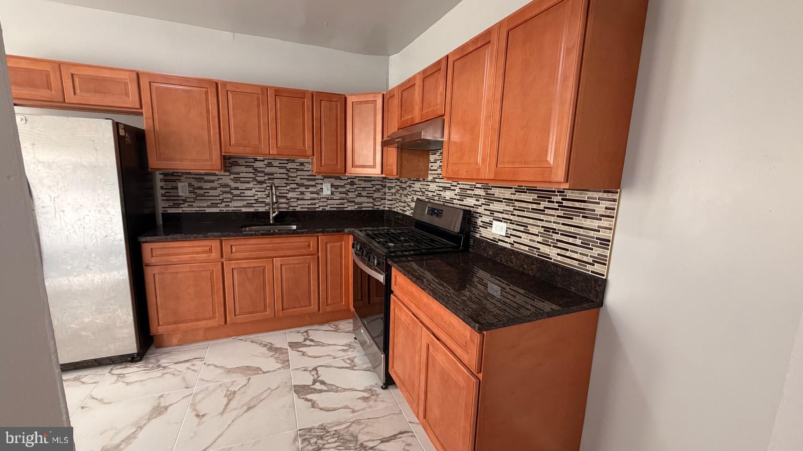4406 Higbee Street Philadelphia, PA 19135 - Photo 11 of 36 a kitchen with granite countertop a sink stove and cabinets