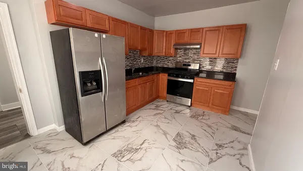 a kitchen with granite countertop a refrigerator and a sink