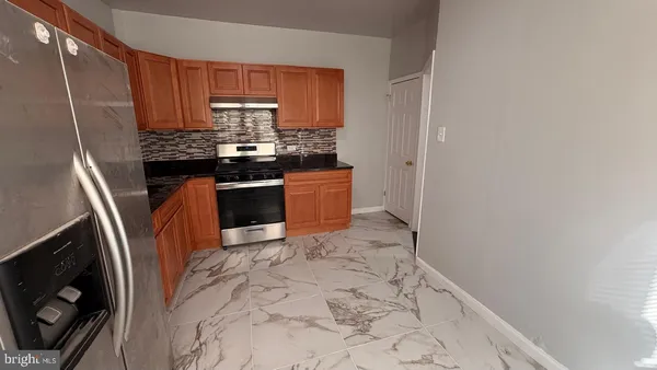 a kitchen with stainless steel appliances a stove a sink and a refrigerator