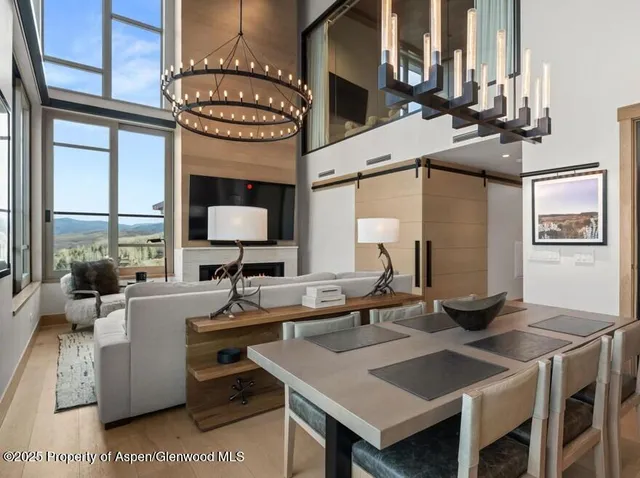 a living room with couches a large dining table and large window with table